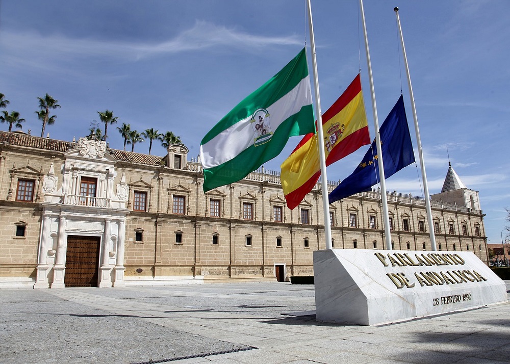 The Andalusian Parlament, a goverment buuilding, with Andalusia, Spain and Europe flags in front.