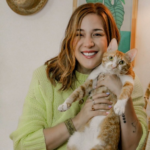 Estela Cuesta, an animal lover who enjoys talking about cats and dogs. A photo of Estela and her cat.