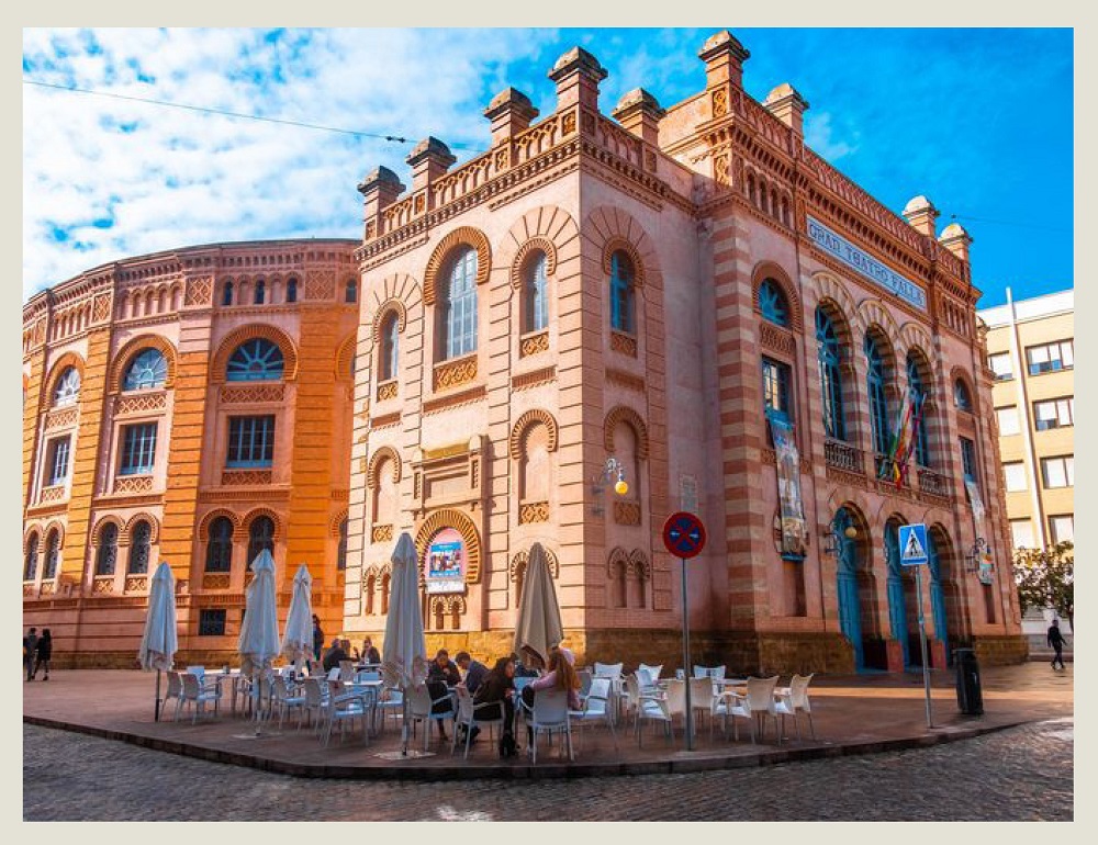 A pic of a modern Andalusian building using Moorish architecture, with people in a restaurant.
