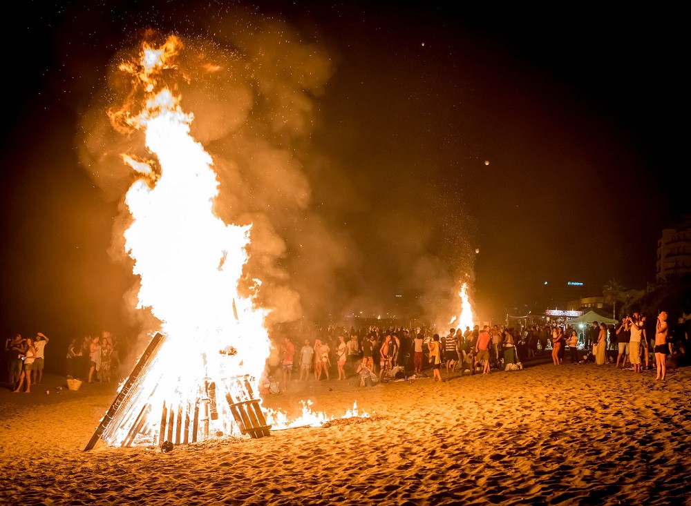 People enjoying the Noche de San Juan in a beach.