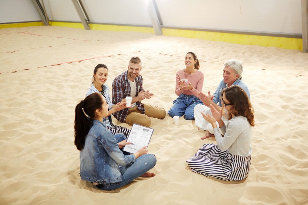 Turma de espanhol reunida na praia de La Malagueta durante a aula